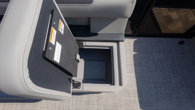 Slide: The Image of An open storage compartment on a boat with gray upholstery and carpeted flooring. - 9