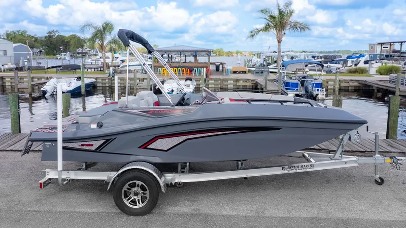 Slide: The Image of A gray Starcraft J7 Jet Super Sport boat on a trailer, with palm trees and water in the background. - 13