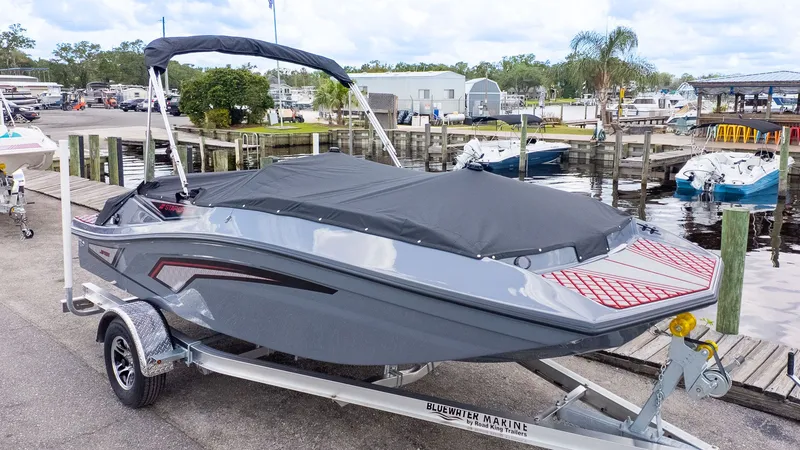 Slide: The Image of A gray 2027 Starcraft J7 Jet Super Sport boat on a trailer at the marina. - 14