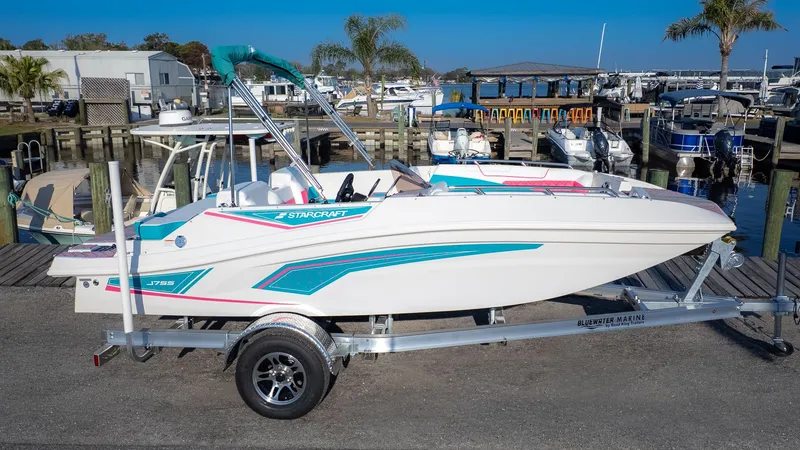 Slide: The Image of A white Starcraft J7 Jet Super Sport boat on a trailer at the marina. - 14