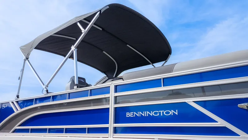 Slide: The Image of Bennington 21 S Fish and Cruise pontoon boat with blue hull and black sunshade. - 18