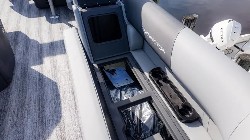 Slide: The Image of The image shows a Bennington boat's gray seating with storage space underneath. - 11