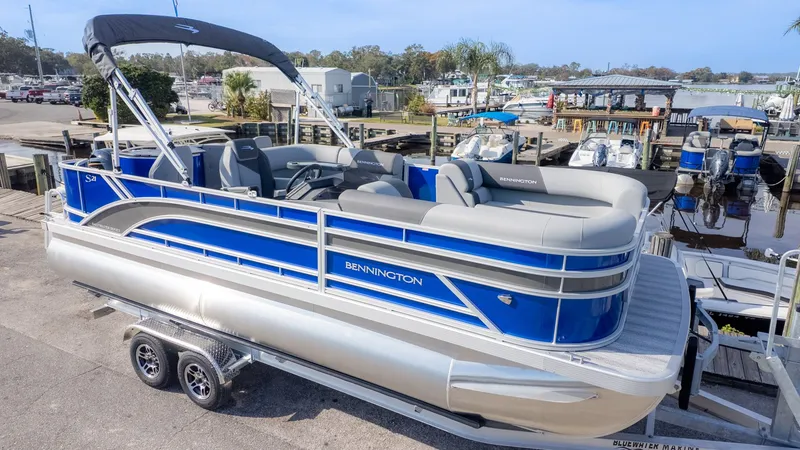 The Image of 2026 Bennington 21 S Fish and Cruise pontoon boat on a trailer at a dock. - 1