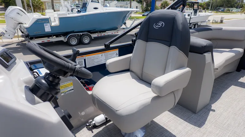 Slide: The Image of The image shows the helm of a Barletta SANZA 22QC boat with a comfortable captain's chair. - 23