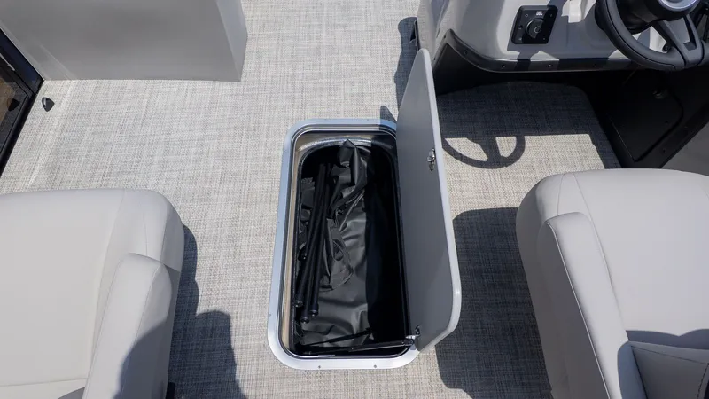 Slide: The Image of An open storage compartment in the floor of a boat with gray carpeting. - 14