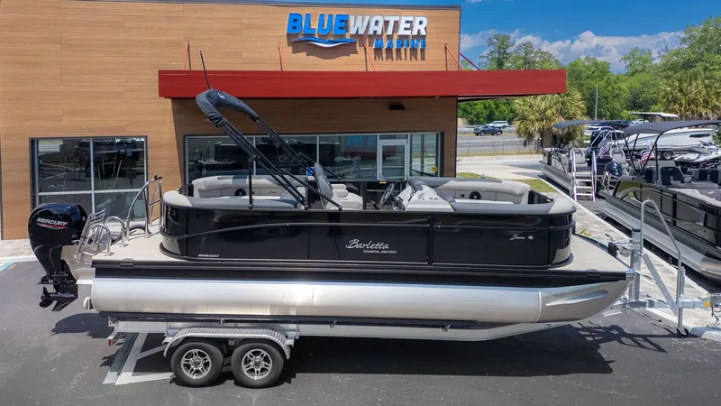 Slide: The Image of A Barletta SANZA 22QC pontoon boat on a trailer in front of a building. - 19