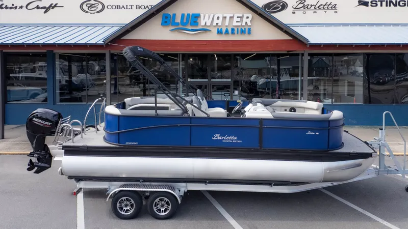 Slide: The Image of 2026 Barletta Sanza S22QC pontoon boat on a trailer in front of a boat dealership. - 18