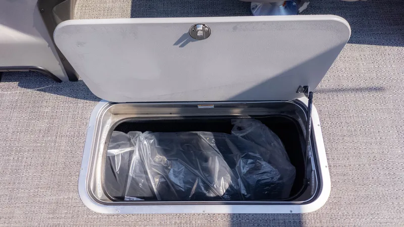 Slide: The Image of An open storage compartment on a boat with a plastic bag inside. - 10