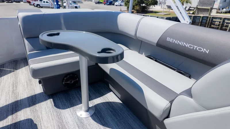 Slide: The Image of Interior of a Bennington 20 S Cruise with gray upholstery and a table with cup holders. - 6