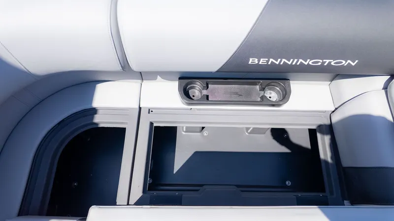 Slide: The Image of Interior of a Bennington 20 S Cruise boat with gray upholstery and storage compartment. - 7