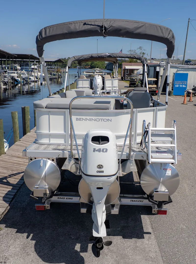The Image of A Bennington 20 S Cruise pontoon boat with a 140 HP motor, docked at a marina. - 1