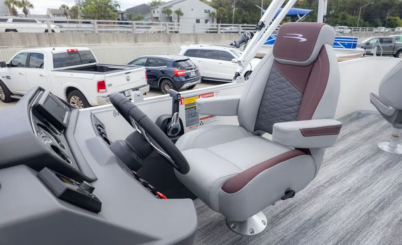 Slide: The Image of The helm of a Bennington 21 S Fish and Cruise boat with a cushioned captain's chair. - 16