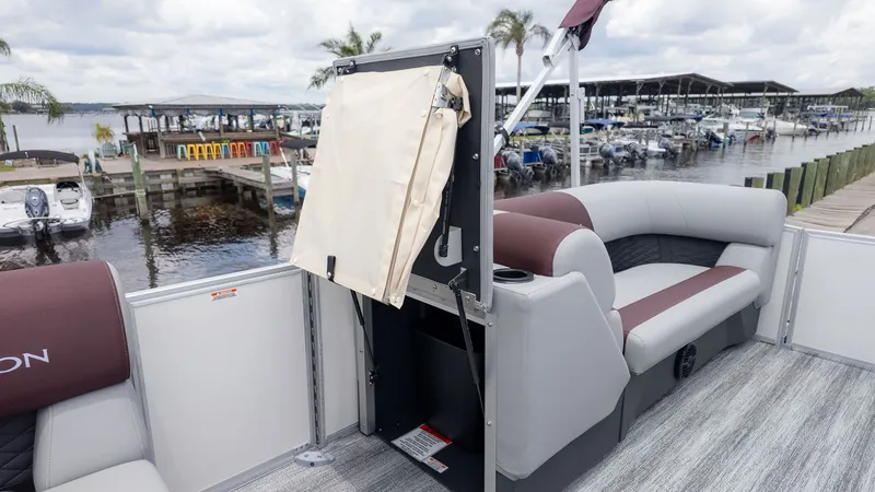 Slide: The Image of The image shows the interior of a 2026 Bennington 21 S Fish and Cruise boat. It features cushioned seating and is docked with other boats. - 10