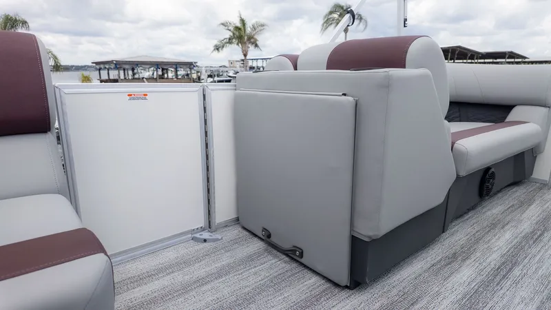 Slide: The Image of Interior of a modern pontoon boat with gray and brown seating, palm trees in the background. - 7