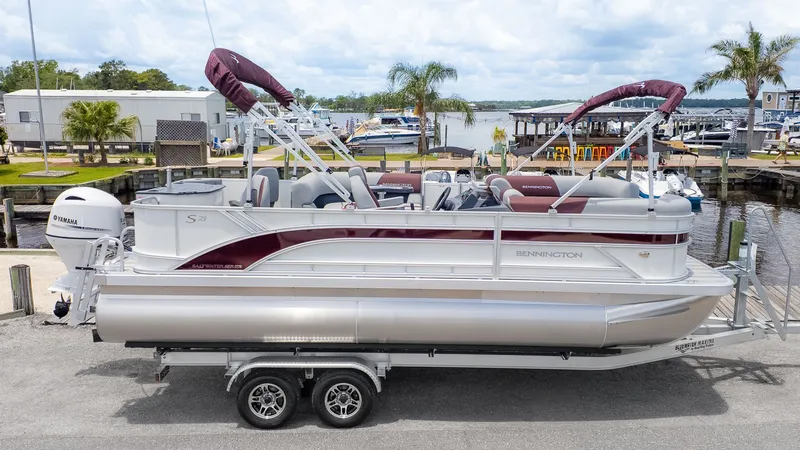 Slide: The Image of A Bennington pontoon boat, model 21 S Fish and Cruise, on a trailer at a marina. - 17