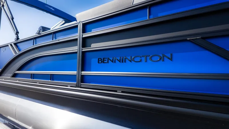 The Image of Close-up of a blue side panel on a Bennington 21 S CRUISE boat with black lettering. - 1