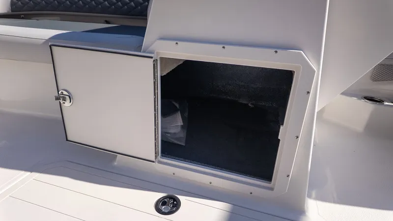 Slide: The Image of An open storage compartment on a boat with cushioned seating in the background. - 18