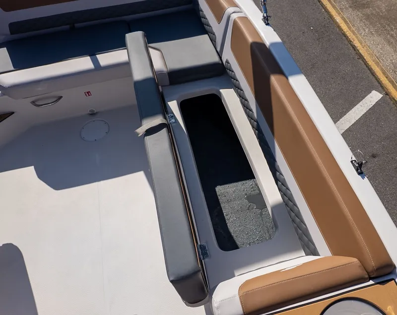 Slide: The Image of The image shows the seating area of a Starcraft SVX 211 OB boat with storage space. - 12