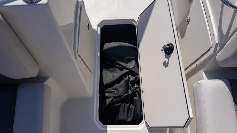 Slide: The Image of An open storage compartment on a boat with a black cover inside. - 17