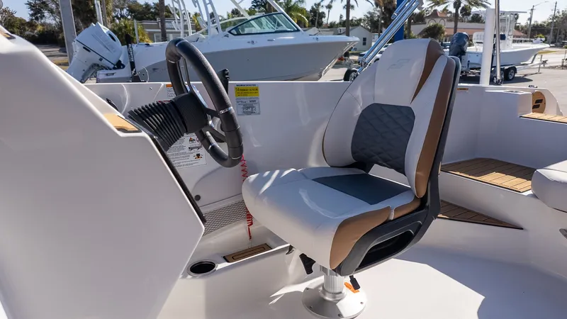 Slide: The Image of The image shows the helm of a Starcraft SVX 211 OB boat with a cushioned seat. - 18