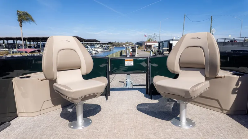 Slide: The Image of Two beige seats on a boat overlooking a marina. - 12