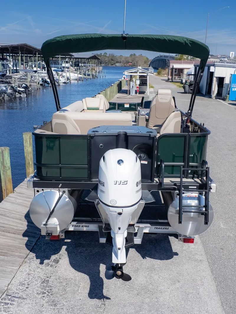 The Image of A Bennington 21 S Fishing pontoon boat with a green canopy and Yamaha engine, docked at a marina. - 1