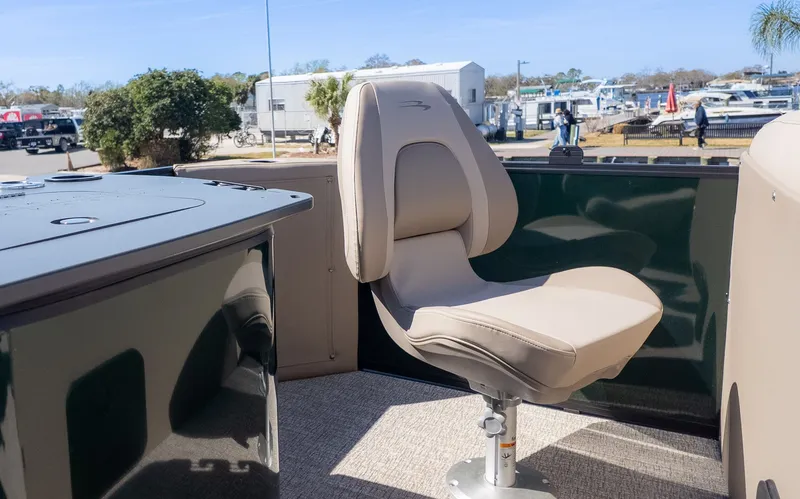 Slide: The Image of A beige swivel chair on a boat, surrounded by green walls and a marina in the background. - 3