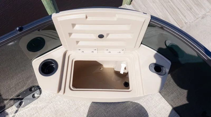 Slide: The Image of An open storage compartment on a Bennington 21 S Fishing boat, with cup holders and a faucet. - 14