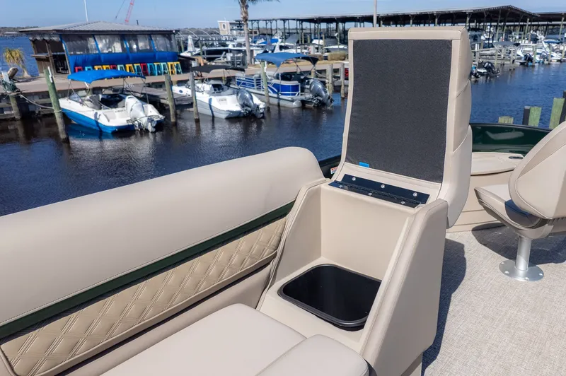 Slide: The Image of Bennington 21 S Fishing 2026: Seat with storage, boats docked in the background. - 8