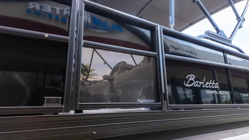 Slide: The Image of Side view of a Barletta ARIA 22QC boat with glossy black finish and branding. - 5