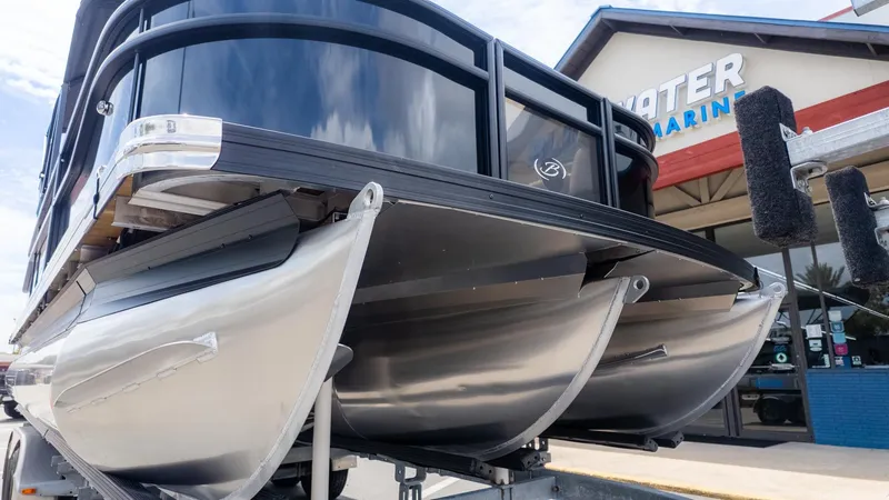 The Image of Close-up of a Barletta ARIA 22QC pontoon boat on a trailer in front of a building. - 1