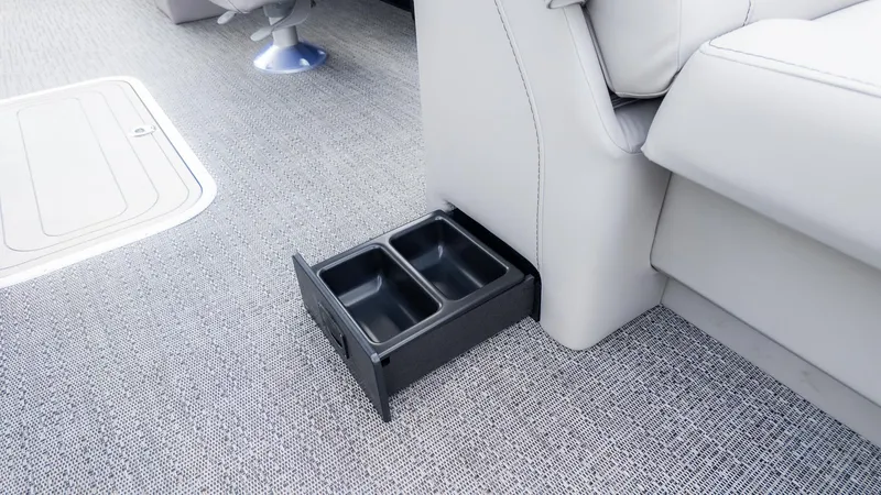 Slide: The Image of A pull-out cup holder in a boat with gray carpet flooring. - 11