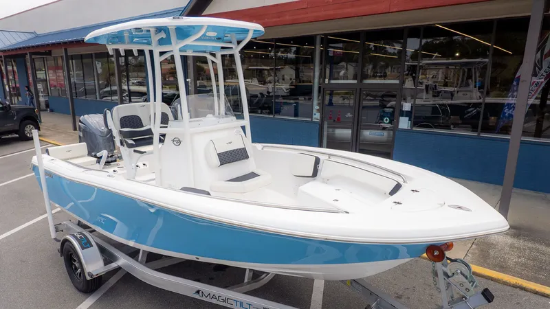 The Image of A 2025 Tidewater 198 CC Adventure boat on a trailer in front of a store. - 1