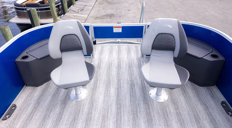 Slide: The Image of Two gray seats on a boat with blue railing, near a dock. - 12