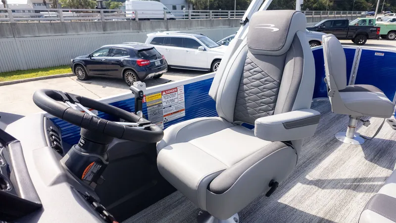 Slide: The Image of The image shows the helm of a Bennington 22 S 4 PT Fishing boat with a cushioned captain's chair. - 17