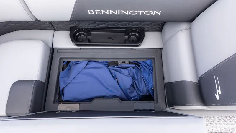 Slide: The Image of A seating area with storage and a blue cover on a Bennington boat. - 11