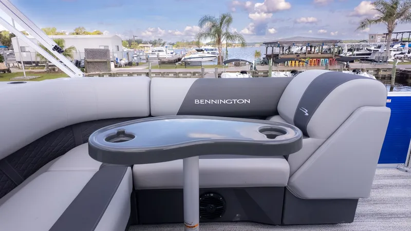 Slide: The Image of The image shows the interior of a Bennington 22 S 4 PT Fishing boat with gray upholstery and a table. - 9