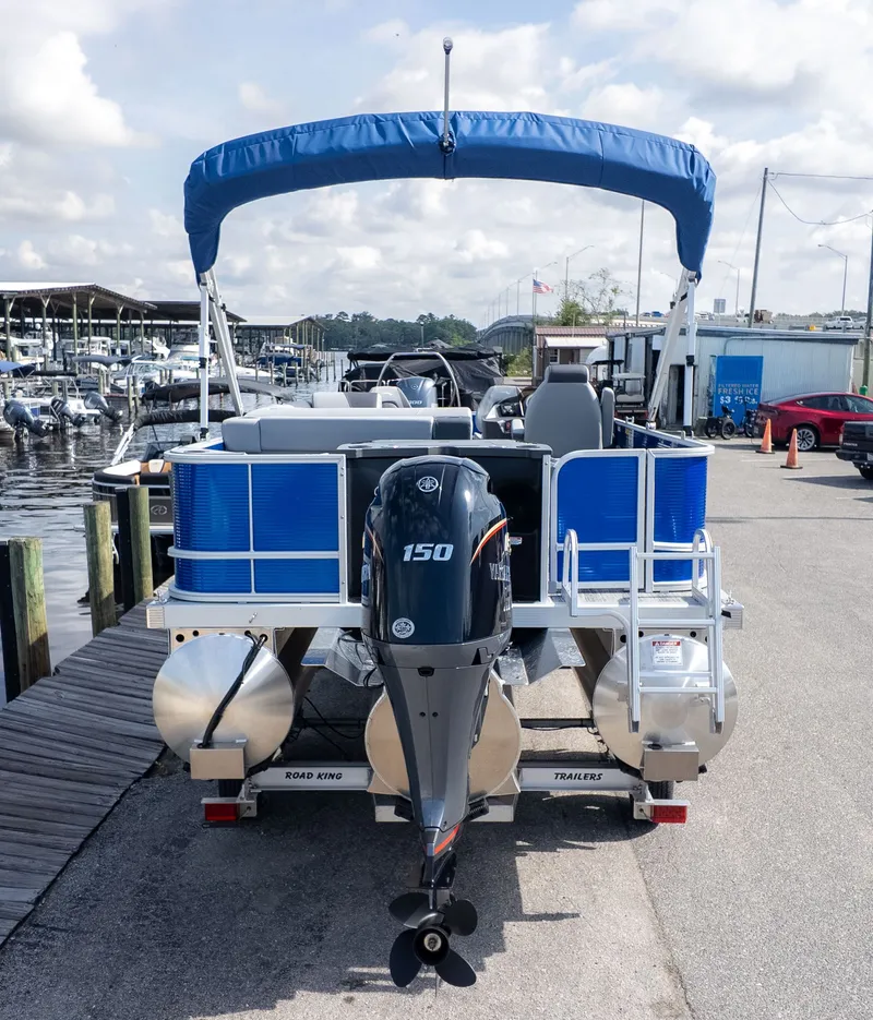 The Image of Bennington 22 S 4 PT Fishing pontoon boat with blue canopy, parked at the dock. - 1