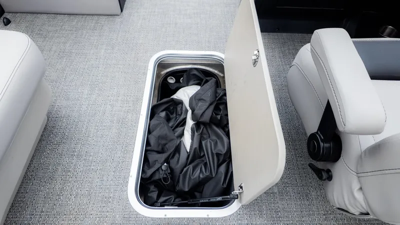 Slide: The Image of An open floor storage compartment on a boat reveals a black cover. - 12