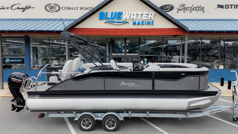 Slide: The Image of Barletta Aria A22CC 2026 on a trailer in front of a boat dealership. - 23