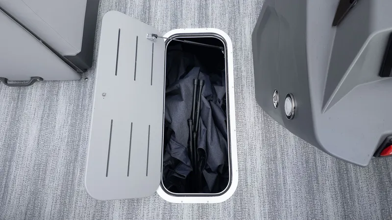 Slide: The Image of An open storage compartment on a boat with gray carpeting. - 10