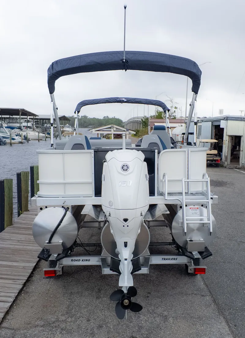 Slide: The Image of The image shows a Bennington 21 S Fish and Cruise boat from the rear, docked at a pier. - 3