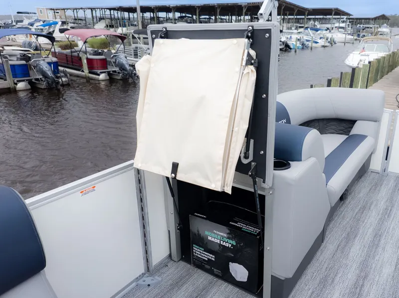 Slide: The Image of A Bennington 21 S Fish and Cruise pontoon boat with gray seating and a marina in the background. - 10