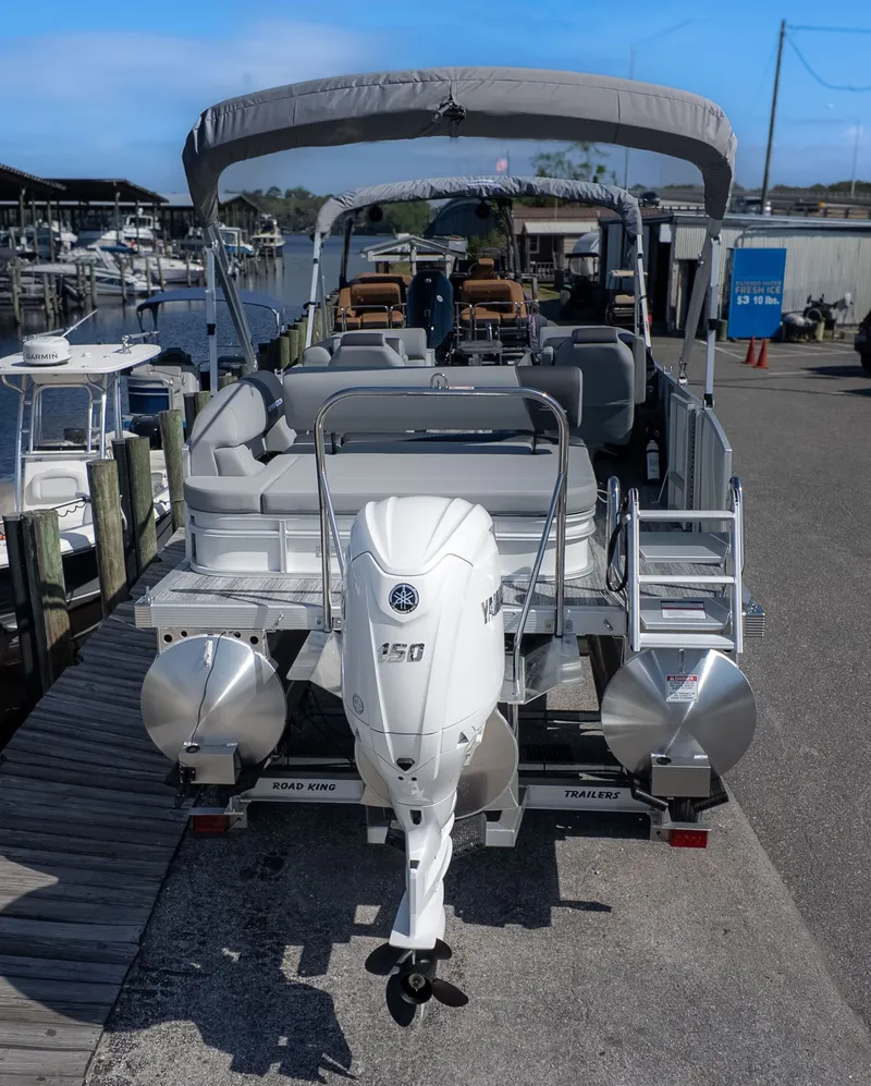 Slide: The Image of A Bennington 21 S Swingback pontoon boat with a 150 HP outboard motor, docked at a marina. - 4