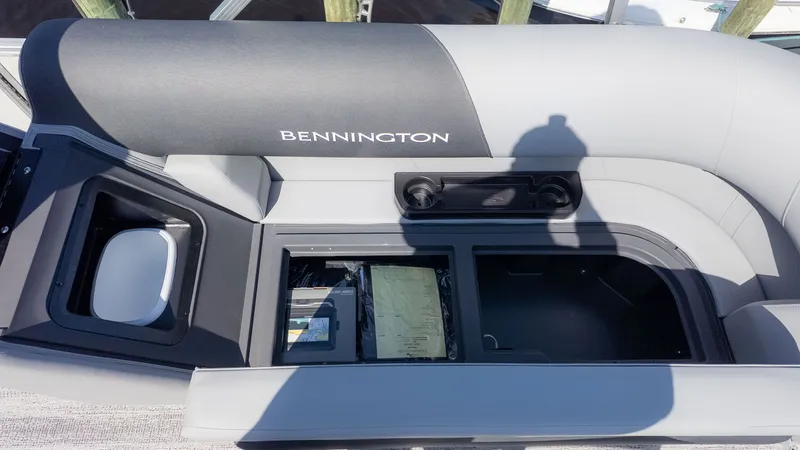 Slide: The Image of The image shows a gray bench seat on a Bennington boat with storage underneath. - 11