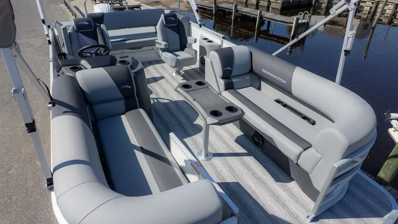 Slide: The Image of The image shows the interior of a Bennington 21 S Swingback pontoon boat with gray seating and a table. - 9
