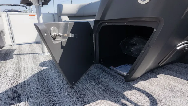 Slide: The Image of Open storage compartment on a Bennington 21 S Swingback boat, featuring gray carpet flooring. - 14