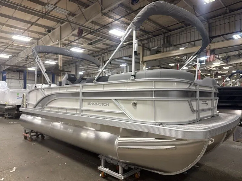 Slide: The Image of A Bennington 21 S Swingback pontoon boat is in a warehouse. It features a gray canopy. - 19