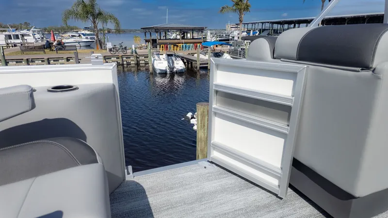 Slide: The Image of The image shows the interior of a Bennington 21 S Swingback boat overlooking a marina. - 7