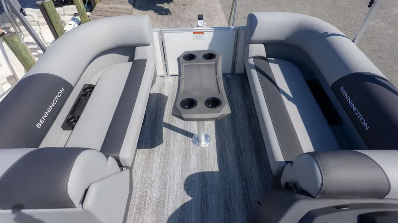 Slide: The Image of Interior of a Bennington 21 S Swingback with gray seating and a table with cup holders. - 11